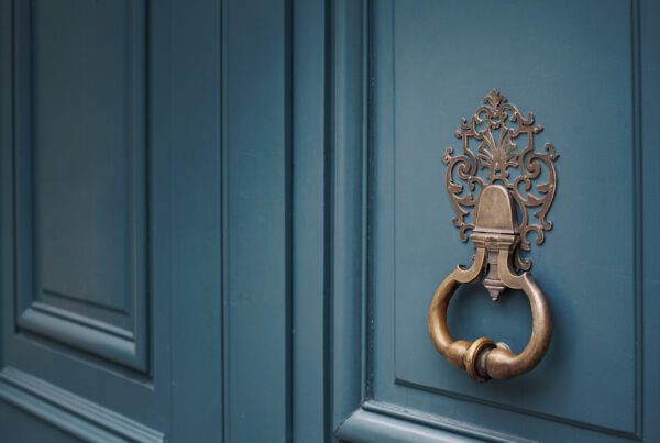 Porte bronze ornée sur porte bleue hôtel particulier luxe Paris rénové