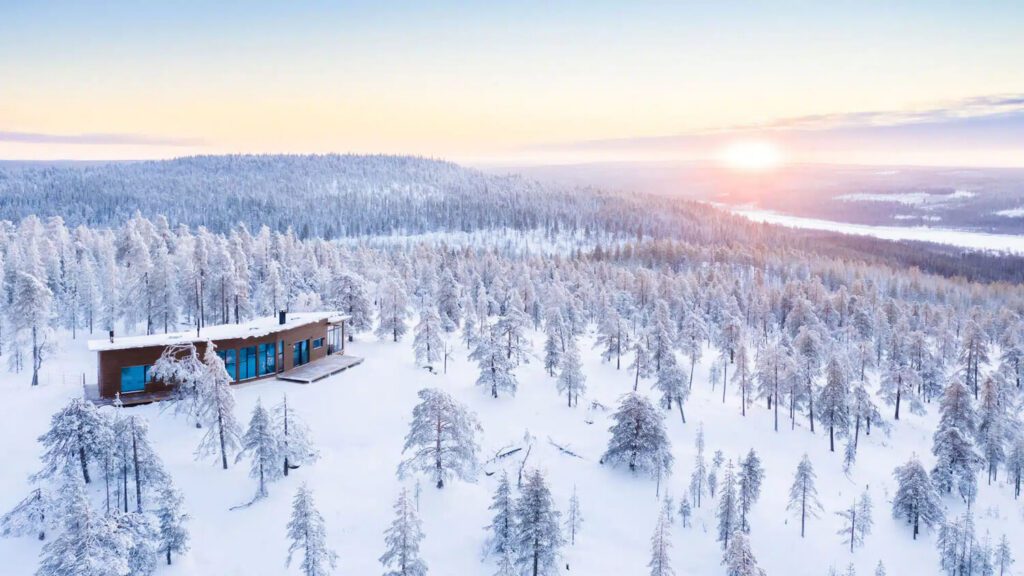 Cabin moderne bois isolée forêt enneigée Laponie Finlande sunset vue lac pour séjour Noël Village Père Noël conciergerie voyages